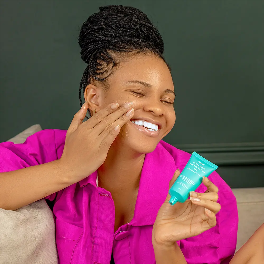 model holding a sunscreen; an important product for melanin-rich skin